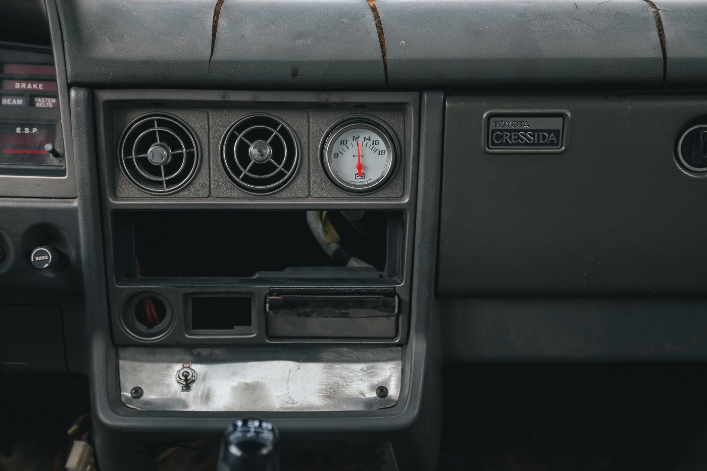 The missing sections are where the AC controls, cigarette lighter, and rear window defrost controls would go. The metal plate with the fan switch is where the OEM radio would be located.